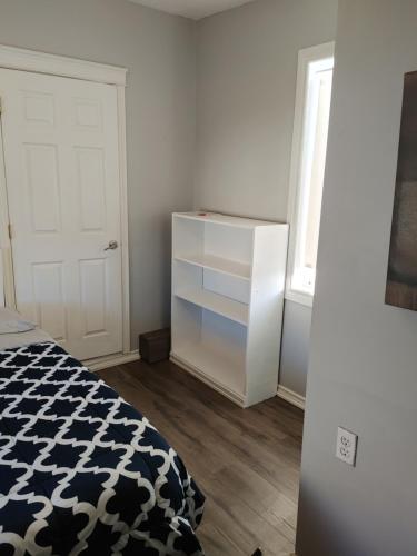 a bedroom with a bed and a white cabinet at 32 jean economic room 1.6 in Saint John