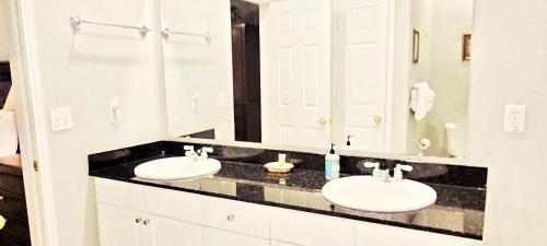 Un baño con dos lavabos y un espejo grande. en Legacy Villa 806, en Gulfport