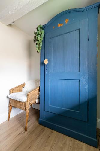a blue door in a room with a chair at Gîte de l'étoile Achenheim 3 chambres - jacuzzi in Achenheim