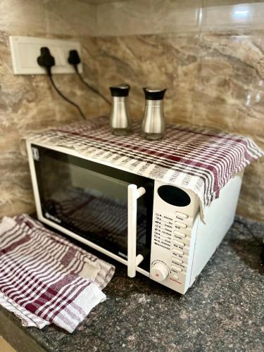 a toaster oven with two vases on top of it at Prince Castle-2BHk Luxurious Apartment/Guesthouse in Hyderabad
