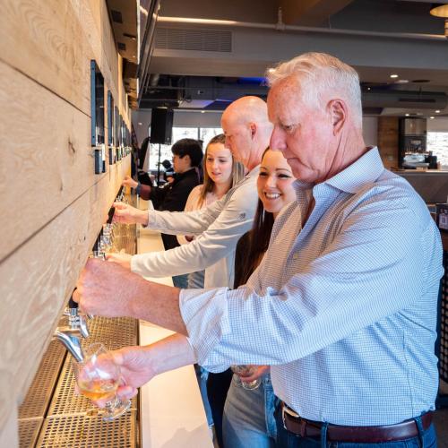 a group of people lined up at a wine bar at Studio Allston Hotel Boston in Boston