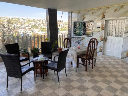 a dining room with a table and chairs on a balcony at huseein rooms in Jerash