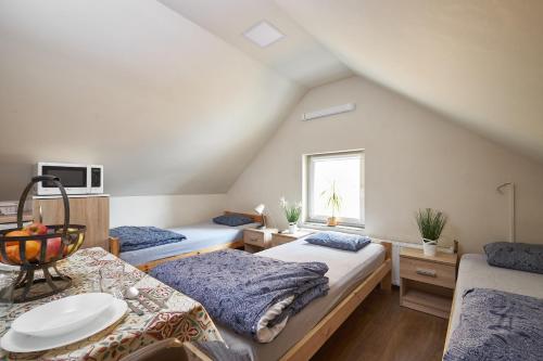 a attic bedroom with two beds and a window at Apartamenty P7 Dzierżoniów in Dzierżoniów