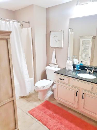 Un baño con inodoro, lavabo y espejo. en Legacy Tower Two 904, en Gulfport