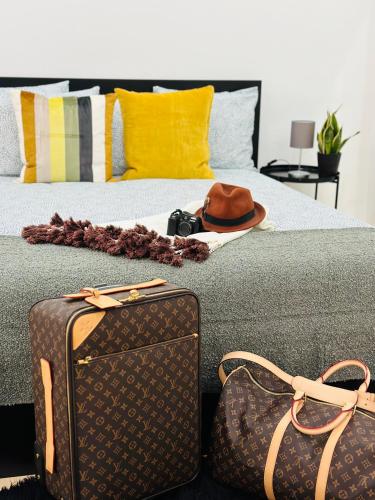 un lit avec deux sacs et un chapeau dans l'établissement New Baixa Chiado Bedrooms, à Lisbonne