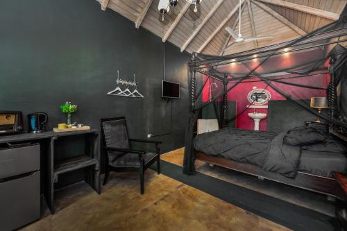 a bedroom with a black bed with a desk and a chair at Mammaloe in Oranjestad