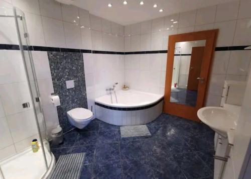 uma casa de banho com uma banheira, um WC e um lavatório. em Spacious 100sq m apartment em Tuchenbach