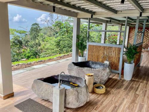 a bathroom with two large stone tubs on a deck at Vibra Healing Lodge y Spa in Teniente Hugo Ortiz