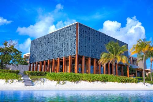 a building on a beach next to the water at NIZUC Resort & Spa in Cancún