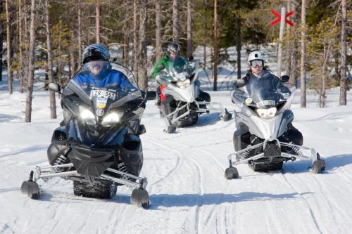 a group of three people riding on snow bikes in the snow at Orsa Grönklitt in Orsa