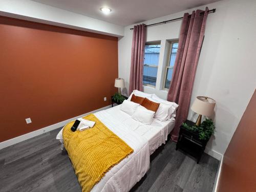 a bedroom with a bed with a yellow blanket on it at Yanne's Place - Philabundance Views in Philadelphia