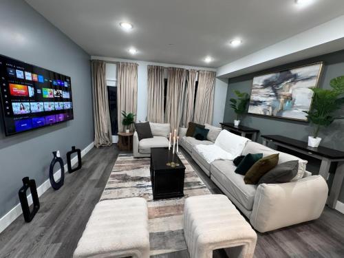 a living room with white couches and a tv at Yanne's Place - Philabundance Views in Philadelphia