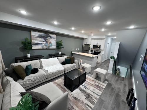 a living room with a white couch and a kitchen at Yanne's Place - Philabundance Views in Philadelphia