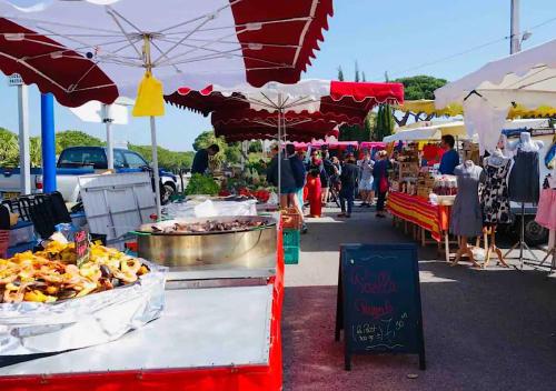 un marché avec un bouquet de produits alimentaires et de parapluies dans l'établissement Les flamants Roses la Capte • Hyères / 4pers, à Hyères