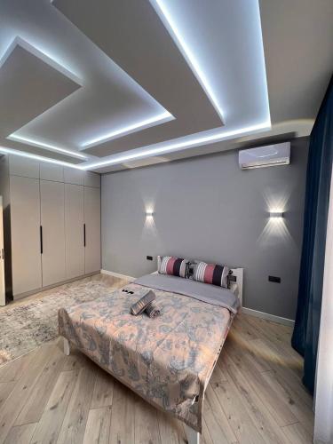 1 dormitorio con 1 cama en una habitación con techo en ЖК Terracotta, en Almaty