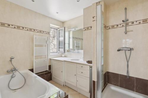 une salle de bain avec une baignoire, un lavabo et une douche dans l'établissement Appartement Boulogne-Billancourt nord Roland Garros, à Boulogne-Billancourt