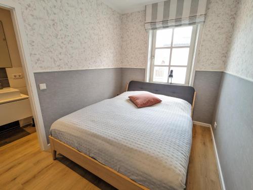 Un dormitorio pequeño con una cama y una ventana. en Lütte Stuv, en Wyk auf Föhr