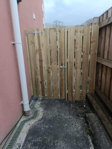 a wooden fence with a gate in front of a building at Unbeatable Llanberis Location, Detached with Parking, Snowdon Views. in Llanberis