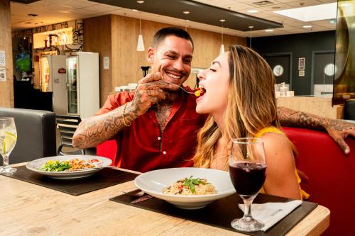 a man and a woman sitting at a table eating food at ibis Copacabana Posto 5 in Rio de Janeiro