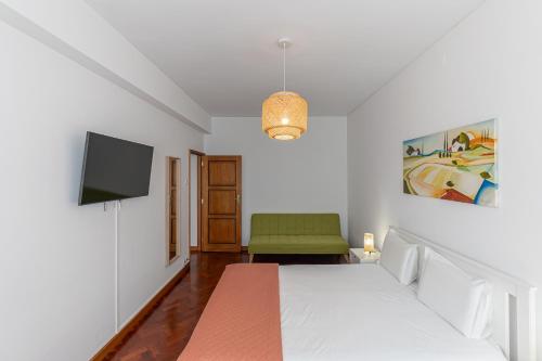 a bedroom with a bed and a television in it at Lolla's City House 2 in Porto