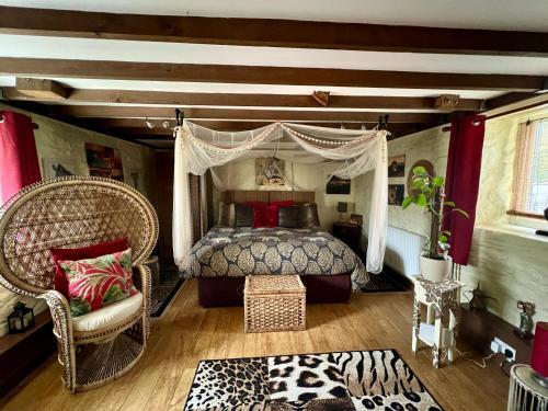 ein Schlafzimmer mit einem Himmelbett und einem Stuhl in der Unterkunft Brecon Boutique Breaks Wild Land in Sennybridge