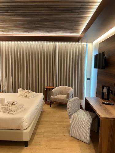 a hotel room with a bed and a chair at Alevic Hotel Sirmione in Sirmione