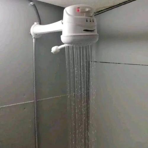 a shower with water coming out of a holder at APHIROOM GUESTHOUSE in Cape Town