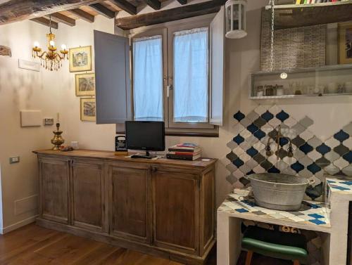 a kitchen with a counter with a computer on it at La Piccola Fattoria nella Campagna Umbra in Badiola