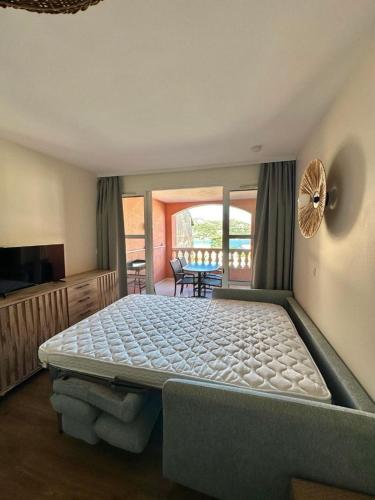 une chambre avec un grand lit et un balcon dans l'établissement Appartement village Cap-Esterel - Agay - Saint-Raphaël, à Agay