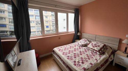 une chambre avec un lit et une grande fenêtre dans l'établissement Appartement Boulogne-Billancourt nord Roland Garros, à Boulogne-Billancourt