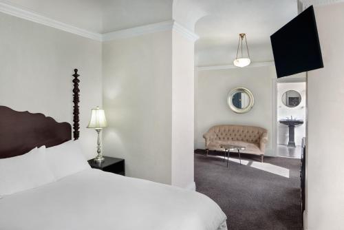カリストガにあるマウント ビュー ホテル & スパの白いベッドルーム(ベッド1台、ソファ付)