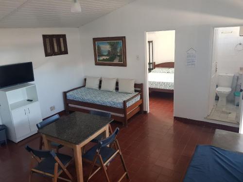 a room with two beds and a table with chairs at APART STUDIOS PONTAL - Aeroporto 400 m - Centro 2,5 Km - Praia 1,5 Km in Ilhéus