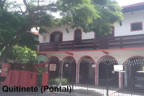 a building with red doors and a fence at APART STUDIOS PONTAL - Aeroporto 400 m - Centro 2,5 Km - Praia 1,5 Km in Ilhéus