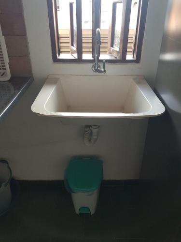 a bathroom with a sink and a toilet under a window at APART STUDIOS PONTAL - Aeroporto 400 m - Centro 2,5 Km - Praia 1,5 Km in Ilhéus