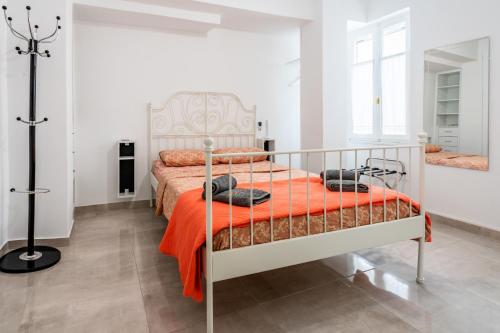 a bedroom with a bed with an orange blanket at Psiri gem from In Vivo Apartments- Spacious 1st floor Apartment with Balcony in Athens' historic center in Athens