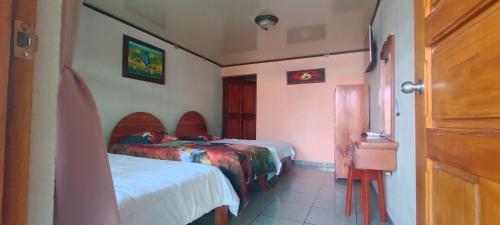a room with two beds in a room with a door at Hotel FAS in Fortuna