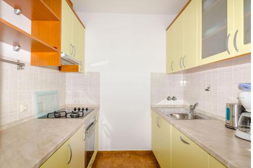 a kitchen with yellow cabinets and a sink at Apartments Mrvelj in Gdinj