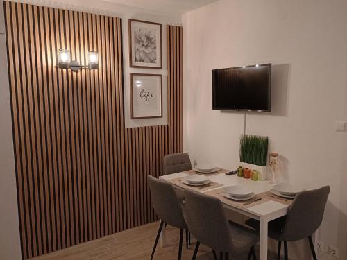 comedor con mesa con sillas y TV en Central Rooftop Apartment with Balcony en Viena