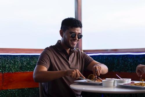 a man sitting at a table with a plate of food at Sonqu Tarapoto in Tarapoto