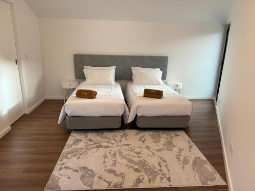 sypialnia z 2 łóżkami i dywanem w obiekcie Oak Retreat House w mieście Lagoa