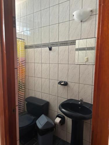La petite salle de bains est pourvue d'un lavabo et de toilettes. dans l'établissement Ñariwalac, à Piura