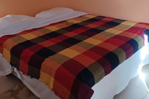 a colorful blanket on a bed in a room at Apartamento à beira-mar. Beachfront apartment in São Gonçalo do Amarante