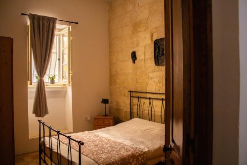 una camera da letto con un letto e una finestra di Blue Door Valletta a La Valletta