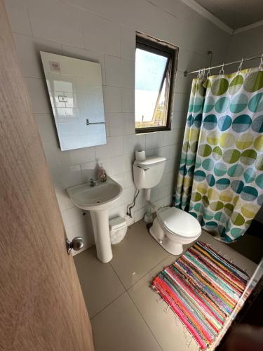 a small bathroom with a toilet and a sink at Cabañas Antonella Los Angeles in Los Ángeles