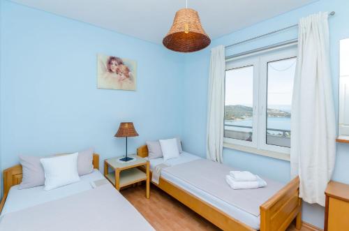 a bedroom with two beds and a window at Apartments Mrvelj in Gdinj