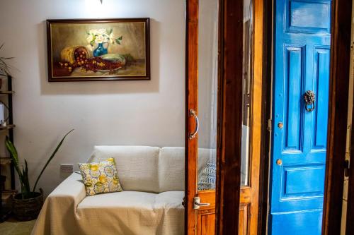 una camera con un divano bianco e una porta blu di Blue Door Valletta a La Valletta
