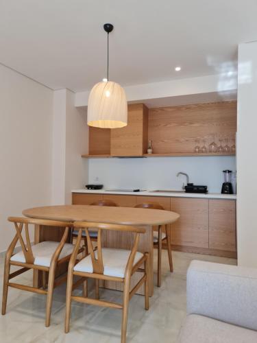 - une cuisine avec une table et des chaises en bois dans l'établissement Gjiri i Lalzit - San Pietro - Savita Premium Apartments, à Durrës