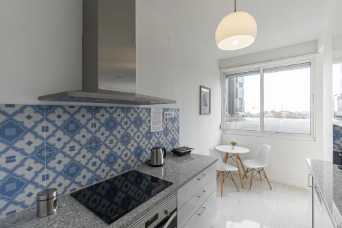 a kitchen with blue and white tiles on the wall at Lolla's City House 2 in Porto