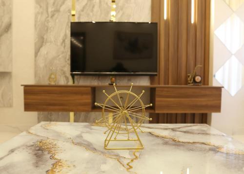 a gold ferris wheel on a table with a tv at Amman in Amman