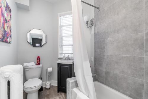 a white bathroom with a toilet and a sink at James St Apartment Unit - Sleeps 6 in Hamilton